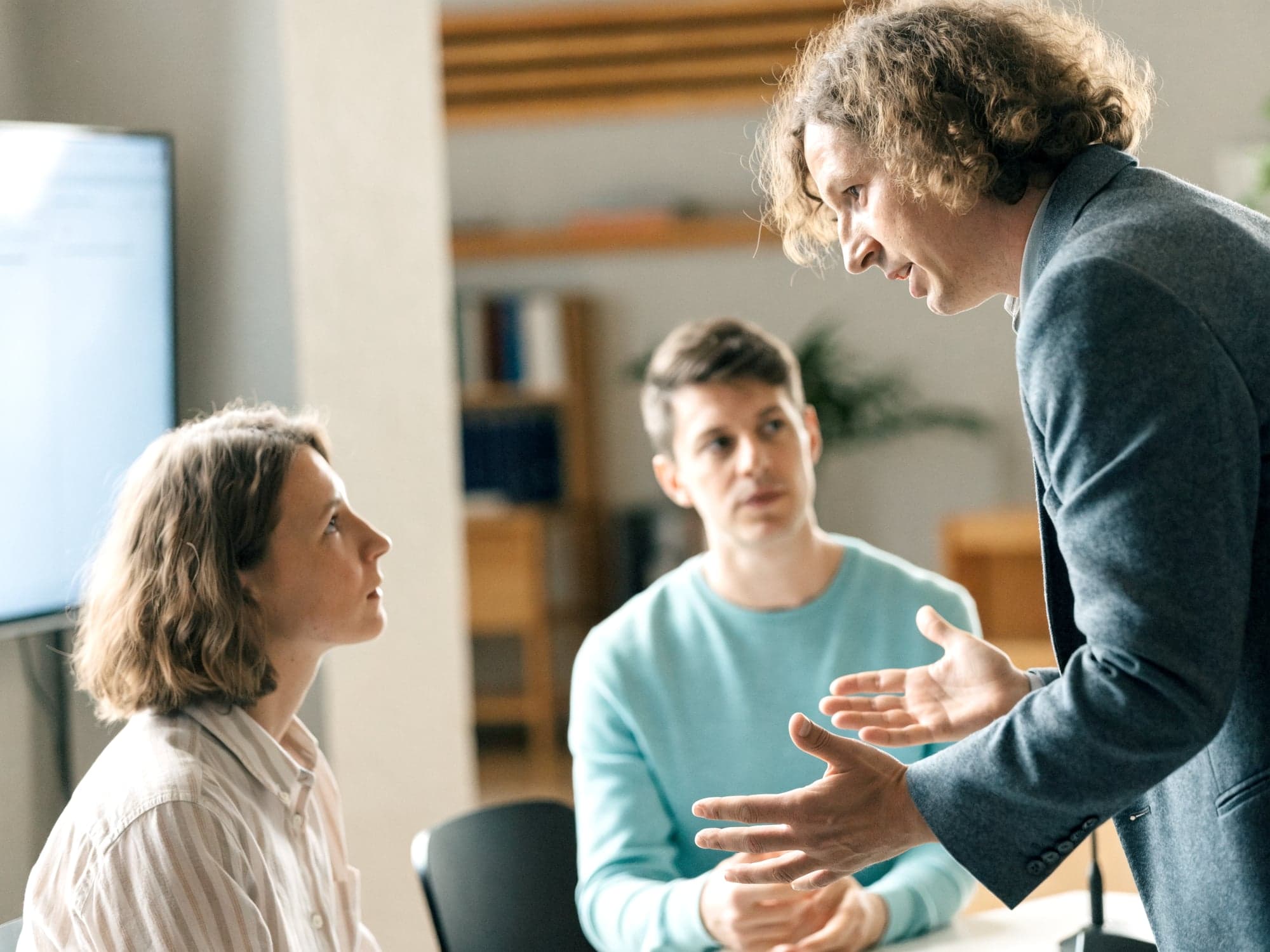 Berater erklärt einem Kundenteam im Besprechungsraum sein Konzept