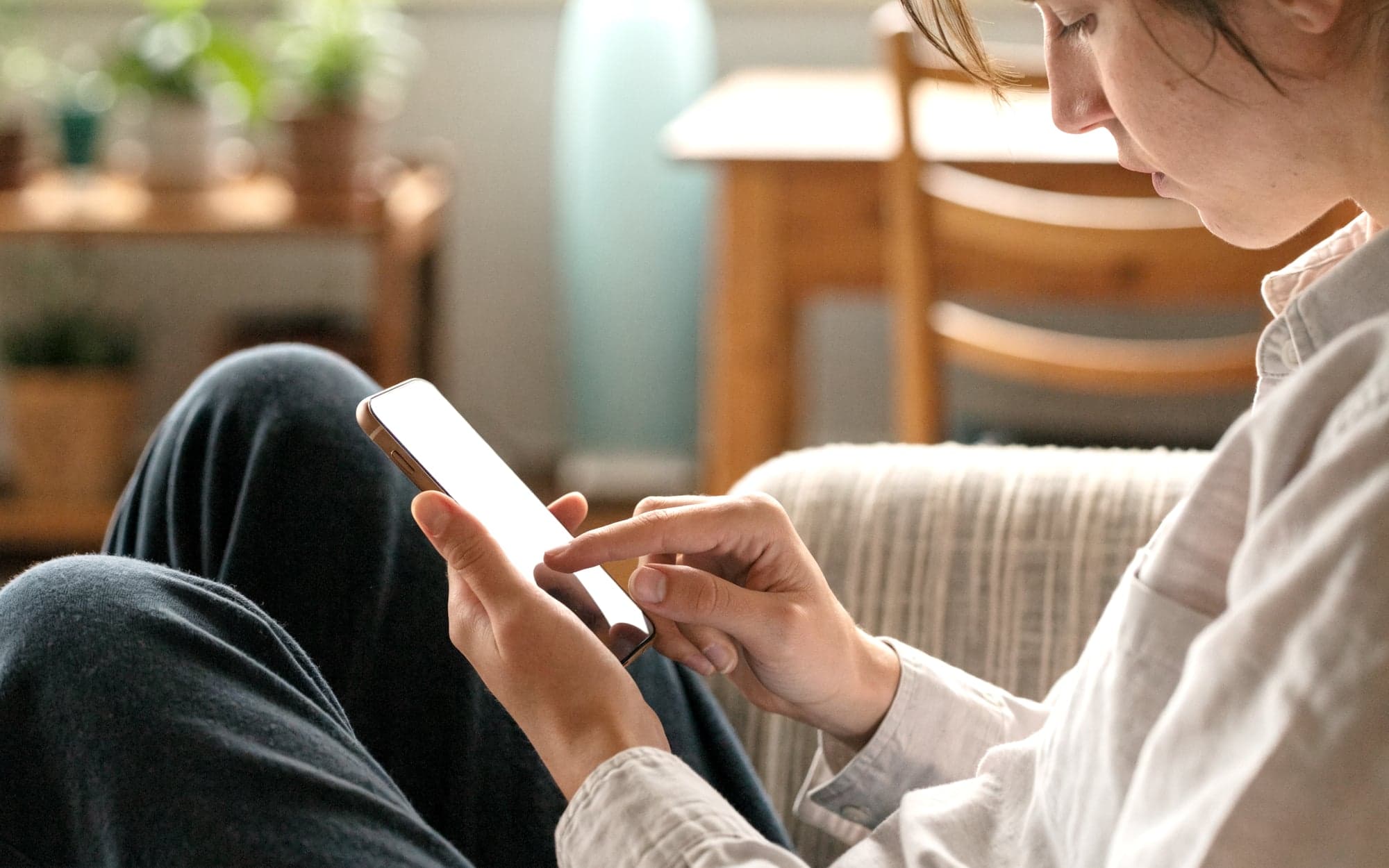 Person scrollt auf dem Sofa durch einen Social-Media-Feed