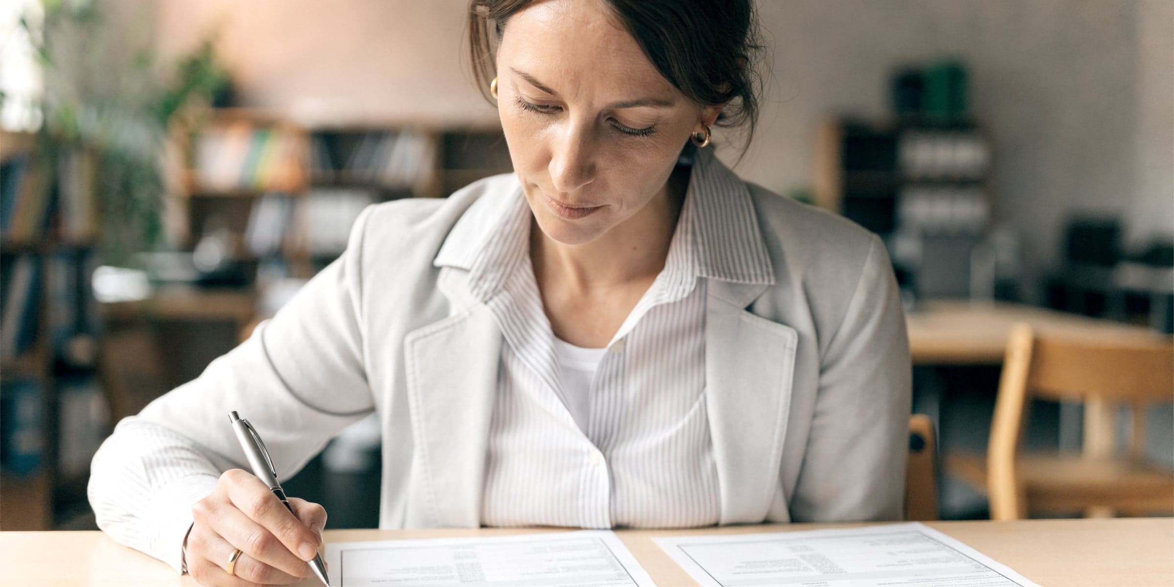 Unternehmerin vergleicht am Schreibtisch zwei Rechnungen