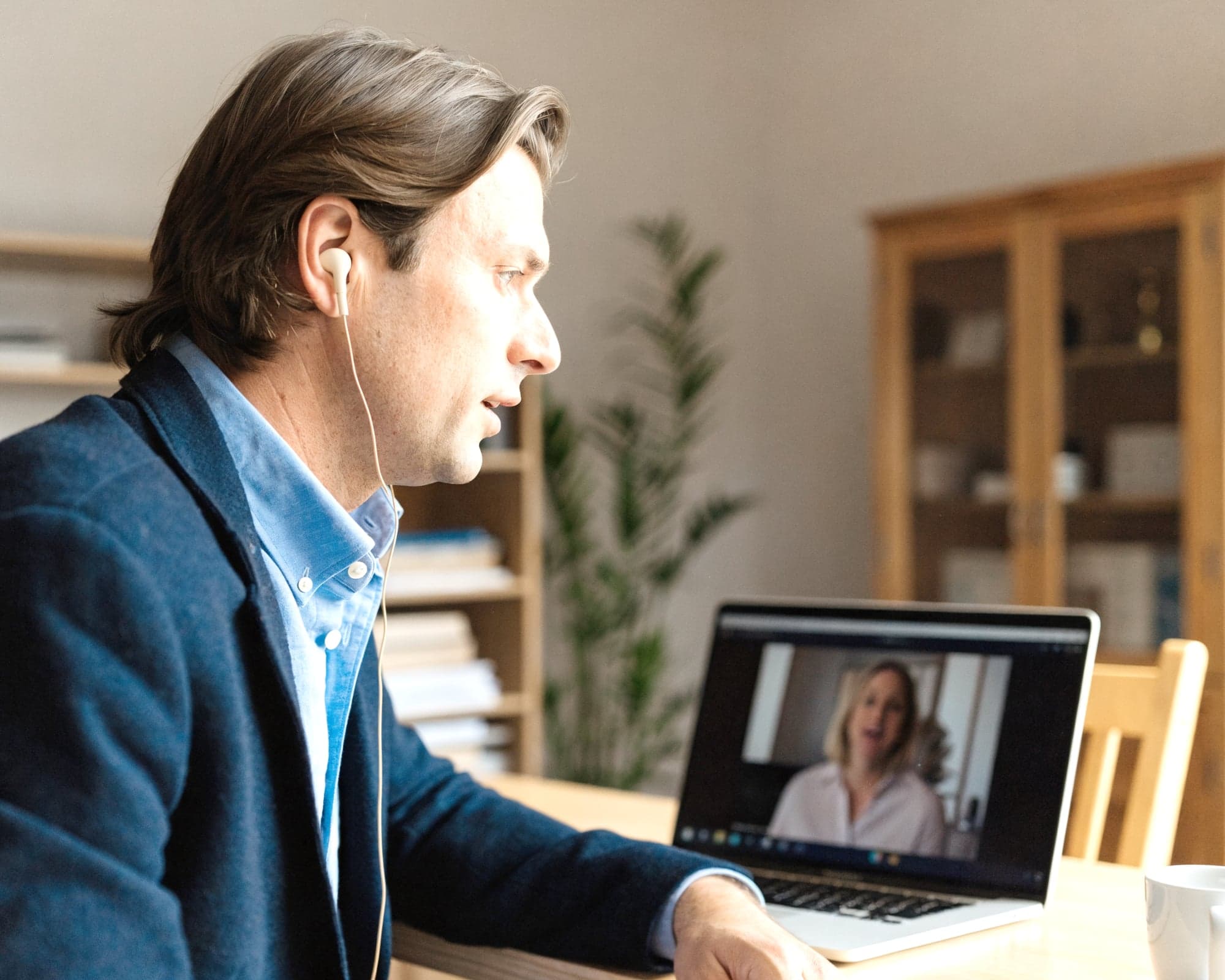 Finanzberater in einer Videoberatung, die Kundin auf dem Laptop