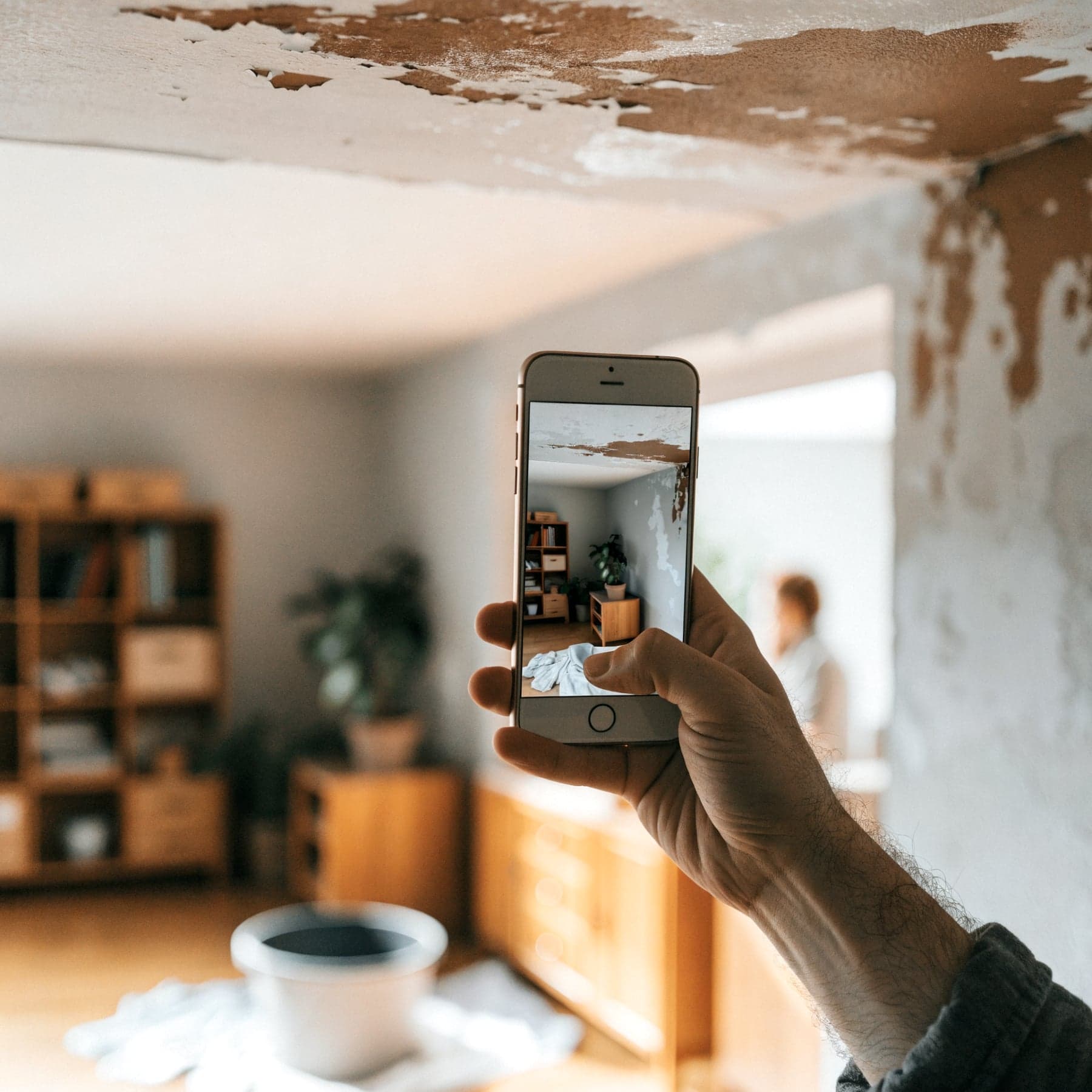 Hand fotografiert einen Wasserschaden für die Versicherung